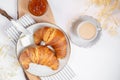 Continental breakfast, a cup of coffee with milk, two croissants, butter and orange jam on a wooden board, top view Royalty Free Stock Photo
