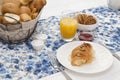 Continental breakfast with fresh croissants, biscuits, bread, jam and orange juice on table Royalty Free Stock Photo