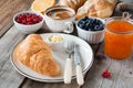 Croissants with coffee, butter, jam and fresh fruits Royalty Free Stock Photo