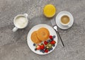 Continental breakfast of Pancakes, fruit, and coffee and orange