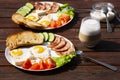 Continental breakfast set of eggs, ham, vegetables and cheese. Bread and coffee on a wooden table. Breakfast for two Royalty Free Stock Photo