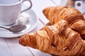 Continental or French breakfast. Croissants and cup of black coffee with sugar and spoon