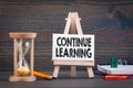Continue learning. Sandglass, hourglass or egg timer on wooden table Royalty Free Stock Photo
