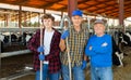 Continuity of generations - portrait of farmers of different ages against the backdrop of cowshed