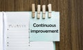 Continuous improvement notes paper and a clothes pegs on wooden background Royalty Free Stock Photo