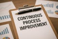 Continuous Process Improvement printed on white paper sheet placed near office equipment Royalty Free Stock Photo
