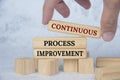 Continuous process improvement text on wooden blocks. Continuous improvement concept.