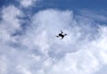 Contour of four engine drone with camera flying in the blue sky with white clouds on sunny day Royalty Free Stock Photo