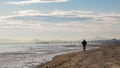 Male figure in the backlight on the shores of the winter sea in Rimini