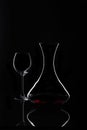 Decanter with red wine and glass at black background
