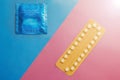 Contraception pills and condom on blue and pink background. Royalty Free Stock Photo