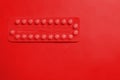 Contraception pills on red background. Female contraceptives concept. Royalty Free Stock Photo