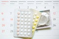 Contraceptive control pills and condom on date of calendar calculate date Royalty Free Stock Photo