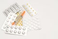 Contraceptive tablets in packages and without on a light background.