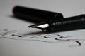 Contract conclusion concept: Macro close up of isolated black ink pen and handwritten signature on white paper focus on tip of Royalty Free Stock Photo