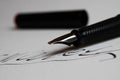 Contract conclusion concept: Macro close up of isolated black ink pen and handwritten signature on white paper focus on tip of Royalty Free Stock Photo