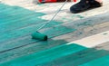 Contract painter painting a floor with green paint