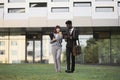 Male and female business partners shaking hands after signing contract, standing outside office Royalty Free Stock Photo