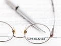 Contract and silver pen through spectacles Royalty Free Stock Photo