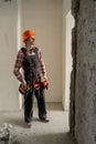 contractor builder with tool belt and hardhat inspection at construction site. worker and residential building. Royalty Free Stock Photo