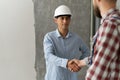Contractor and client shaking hands with team builder in renovation site. Partnership, contractor Royalty Free Stock Photo