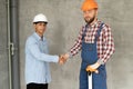 Contractor and client shaking hands with team builder in renovation site. Partnership, contractor Royalty Free Stock Photo