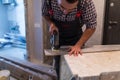 Man worker Contractor Cutting laminate flooring lengthwise. Workers Cutting laminate flooring with electric saw. Royalty Free Stock Photo