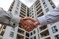 Contractor and Engineer Shaking Hands in Front of Modern Building Under Construction Royalty Free Stock Photo