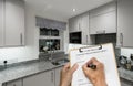 Builder fills out estimate for decorating small compact modern kitchen