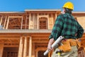 Contractor Facing New House Wood Framing at Construction Site