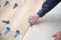 Contractor hands laying ceramic wood effect tiles using tile levelers. Royalty Free Stock Photo