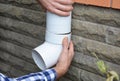 Contractor hands repair, install rain gutter downspout pipe. Guttering, Rain Chain Drainage. Royalty Free Stock Photo