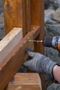 Contractor hanyman using tools to buildi a horizontal fence made from stained cedar