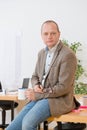 Contractor Holding Coffee Cup And Eyeglasses On Desk In Office