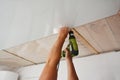 Contractor installing, renovate, repair white PVC Ceiling Boards with screw gun in the new room Royalty Free Stock Photo