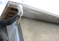 Contractor installing roof gutter downspout pipe.