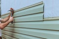 Contractor installing vinyl siding plastic panels on facade wall of a new home Royalty Free Stock Photo