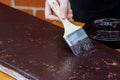 Contractor painting a wooden baseboard for renovation