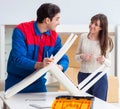 Contractor repairman assembling furniture under woman supervisio Royalty Free Stock Photo