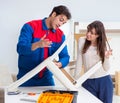 Contractor repairman assembling furniture under woman supervisio Royalty Free Stock Photo