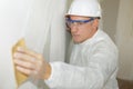 Contractor sanding drywall mud using sand trowel Royalty Free Stock Photo