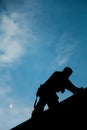 Contractor in Silhouette working on a Roof Top