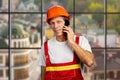 Contractor with smartphone on blurred background.