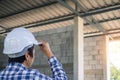 The contractor stood looking at the construction site or building that is currently being renovated or modified. Check the