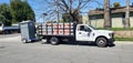 A contractor truck towing a portable toilet parked by the road