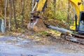 A contractor uproots trees with tractor in forest at preparation for construction of new building