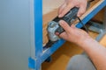 Contractor using oscillating multi functional cutting tool for handyman cut hole in kitchen furniture