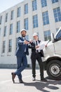 Contractors in formal wear looking at camera while standing near bus outdoors Royalty Free Stock Photo