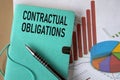 CONTRACTUAL OBLIGATIONS - words on a green piece of paper on the background of a chart and a pen