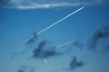 The contrails of several airplanes pervade the blue sky.